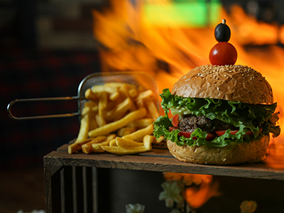 Primer plano de una hamburguesa preparada con papas a la francesa en una canasta